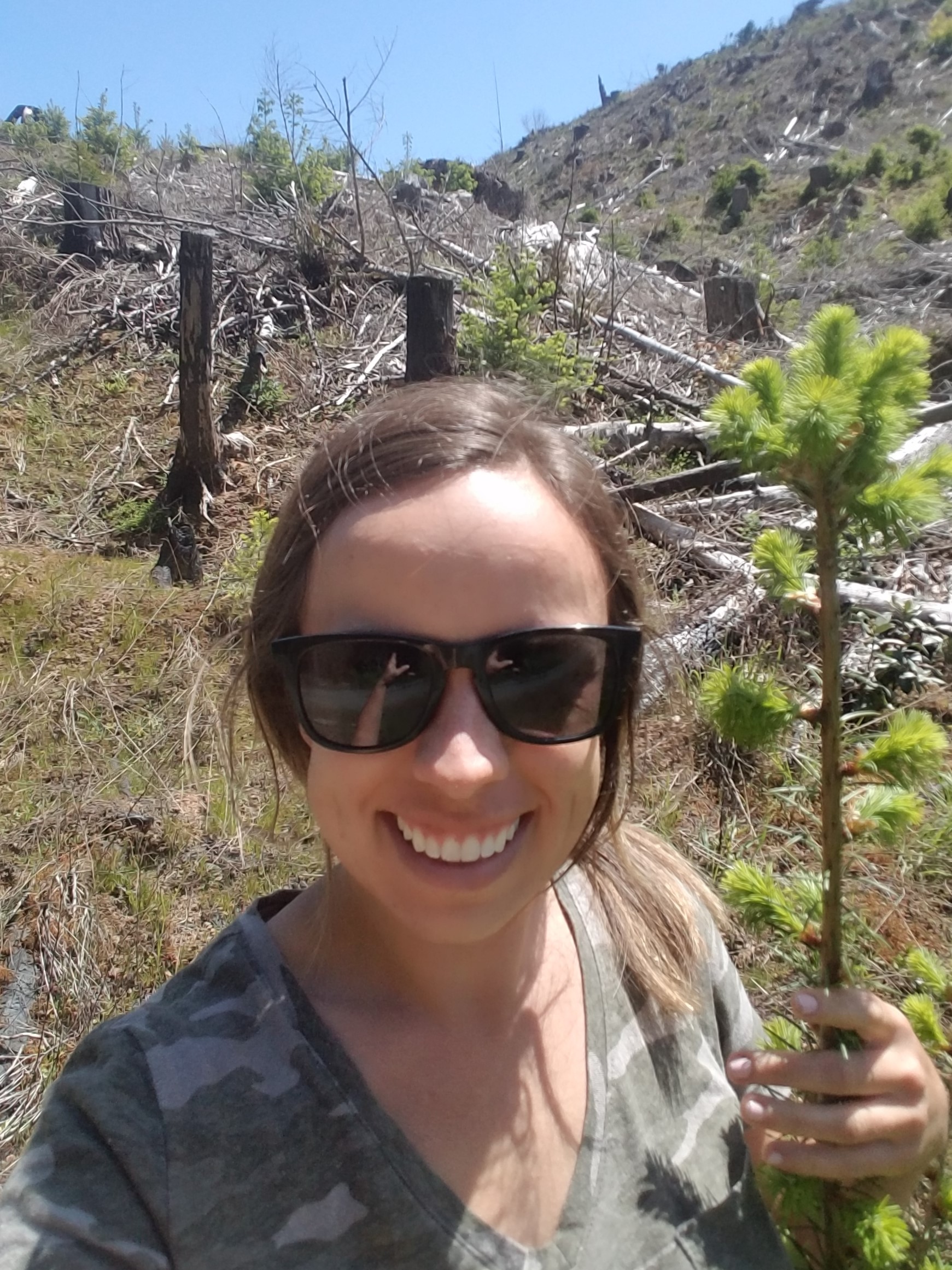 Whitney holding a tree seedling. 