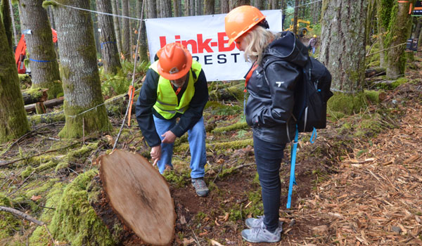 Mike Cloughesy and Erin Isselmann examine a stump at the Pacific Logging Congress