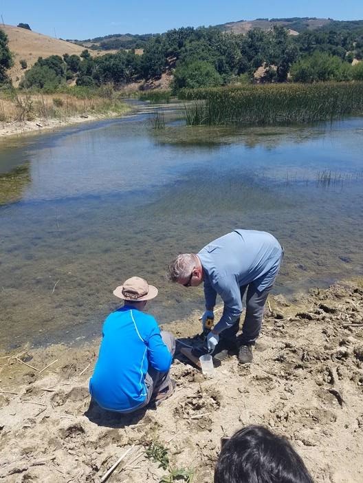 Two people by a body of water.