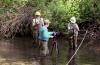 Three scientists in a river